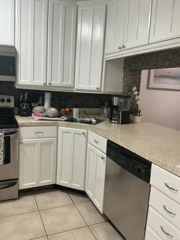 a kitchen with white cabinets sink and white appliances