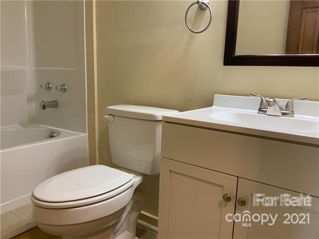 235 South Main Street Wingate, NC 28174 - Photo 8 of 9 a bathroom with a granite countertop toilet sink and mirror