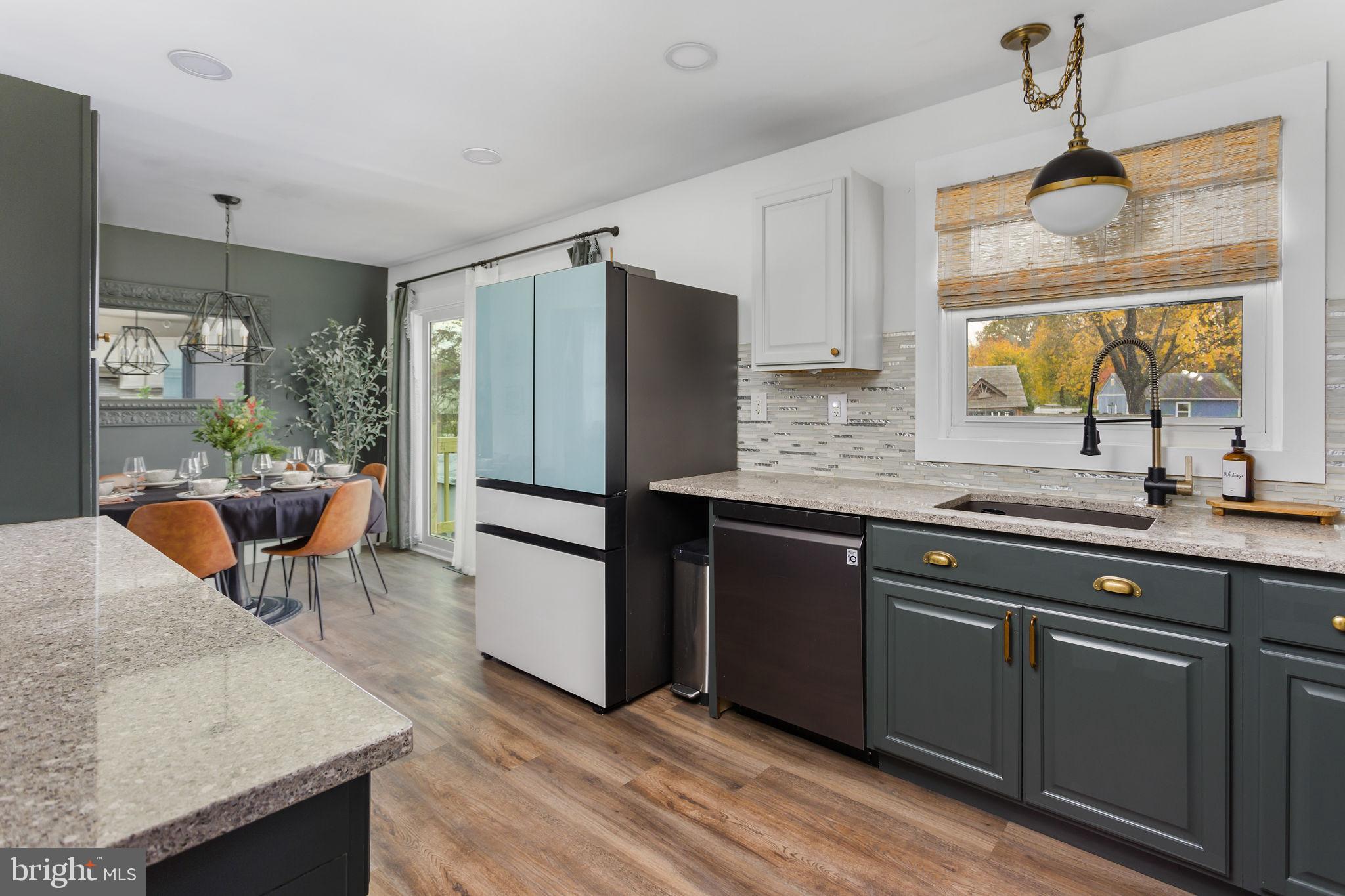 2 Spruce Road Burlington, NJ 08016 - Photo 9 of 34 a kitchen with stainless steel appliances granite countertop a refrigerator a sink dishwasher a stove and white countertops with wooden floor