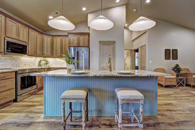 a kitchen with cabinets a sink and chairs