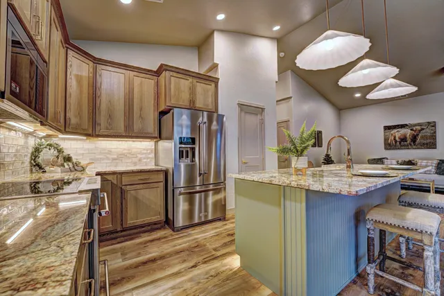 a kitchen with kitchen island stainless steel appliances a sink and cabinets