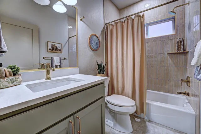 a bathroom with a granite countertop sink a toilet a mirror and shower