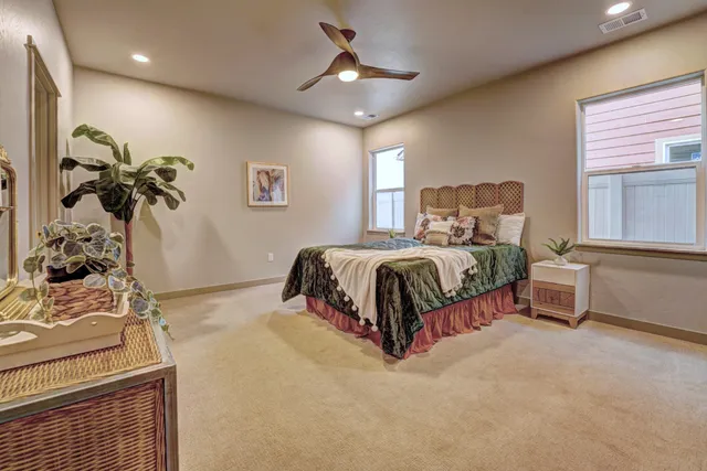 a spacious bedroom with a bed and a chandelier