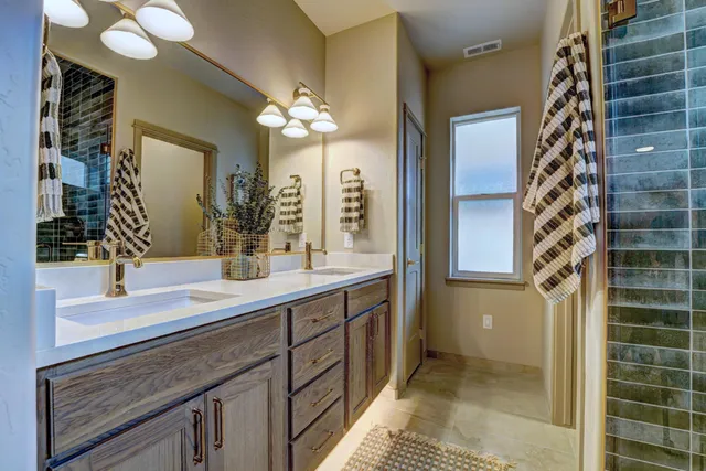 a bathroom with a double vanity sink mirror and shower