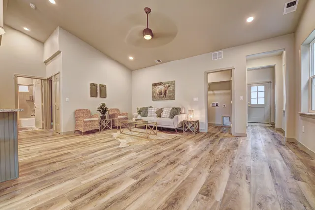 a living room with furniture and a wooden floor