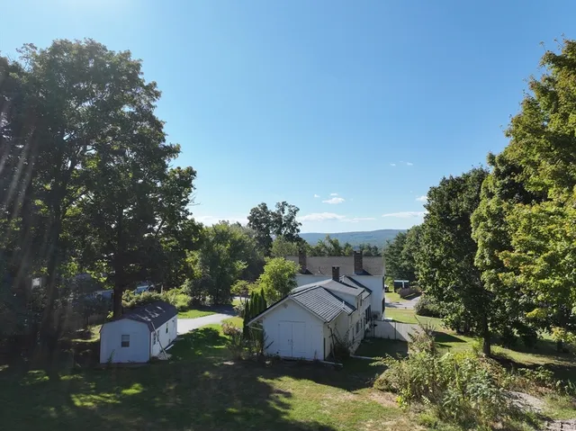 a view of a house with backyard and trees