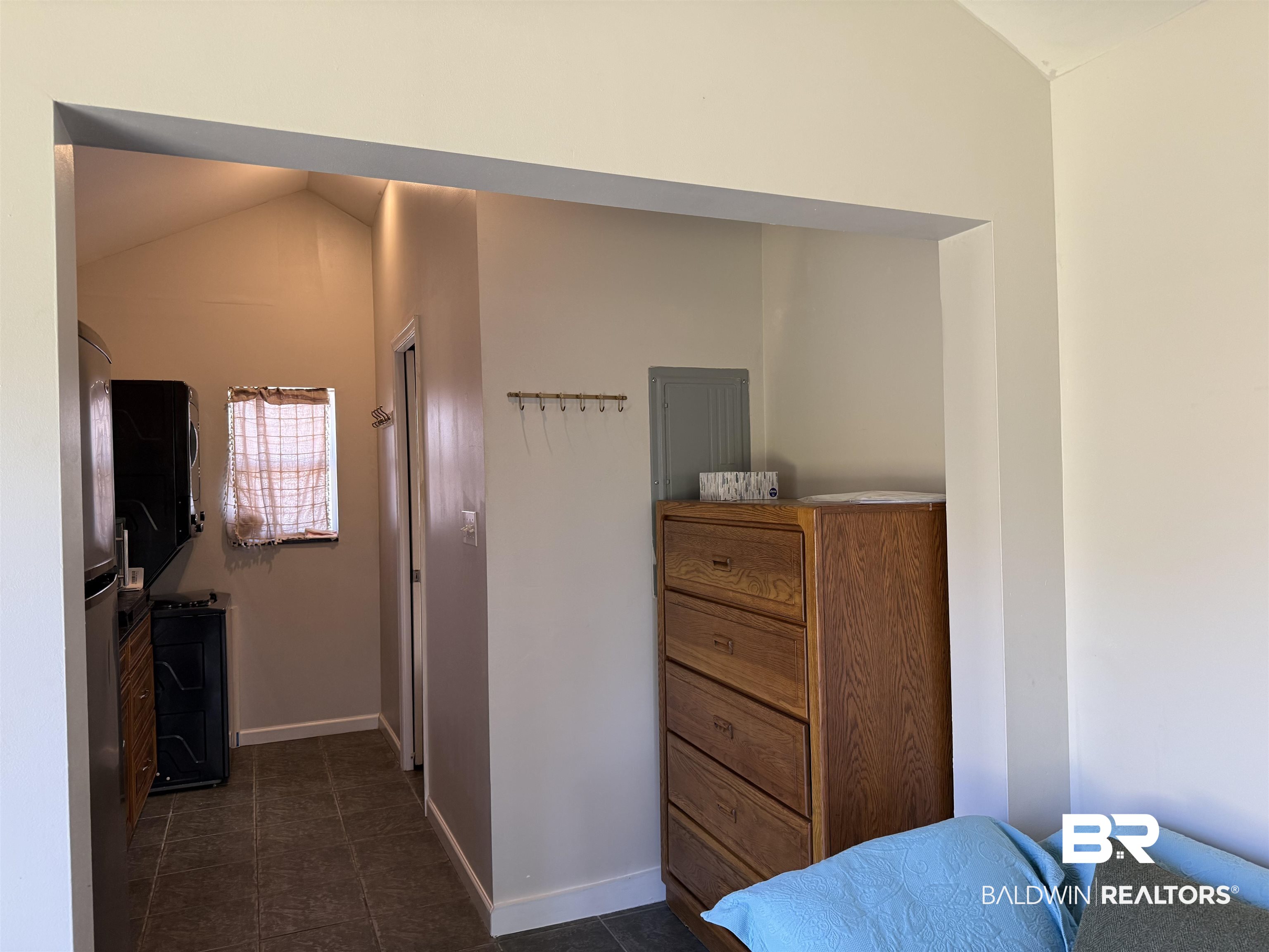 28114 Preserve Trail, Unit 190 Elberta, AL 36530 - Photo 26 of 69 Bedroom with vaulted ceiling, electric panel, dark tile patterned flooring, and freestanding refrigerator