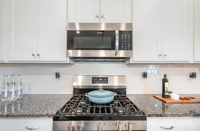 a kitchen with stainless steel appliances granite countertop a stove a microwave and cabinets