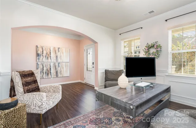 a living room with furniture a flat screen tv and a large window