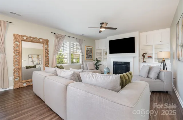 a living room with furniture a fireplace and a flat screen tv