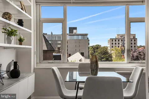 a living room with couches a coffee table and a large window with garden view