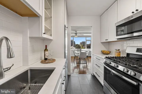 a kitchen with stainless steel appliances a sink stove and cabinets