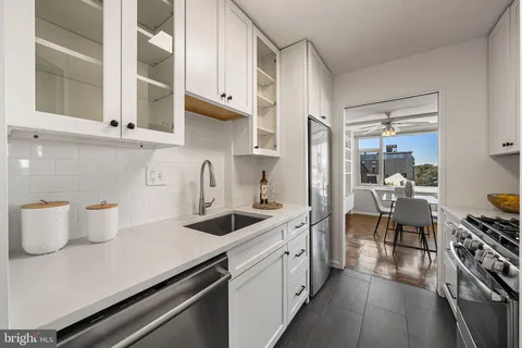 a kitchen with cabinets and steel appliances