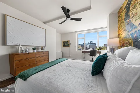a bedroom with a bed and a lamp on dresser