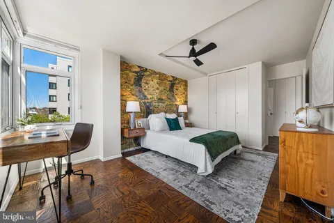 a bedroom with a bed and a lamp on dresser