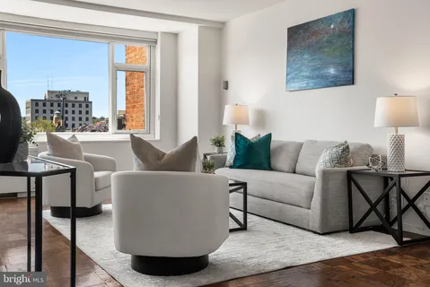 a living room with fireplace furniture and a large window
