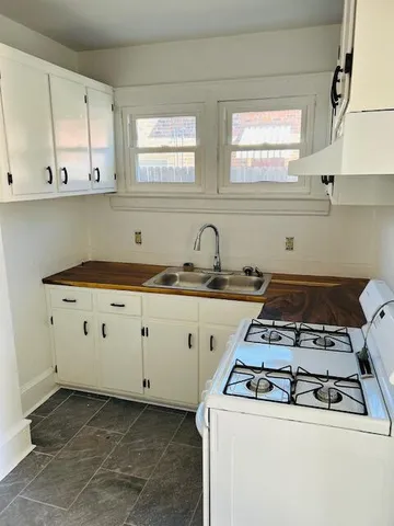 a white stove top oven sitting inside of a kitchen