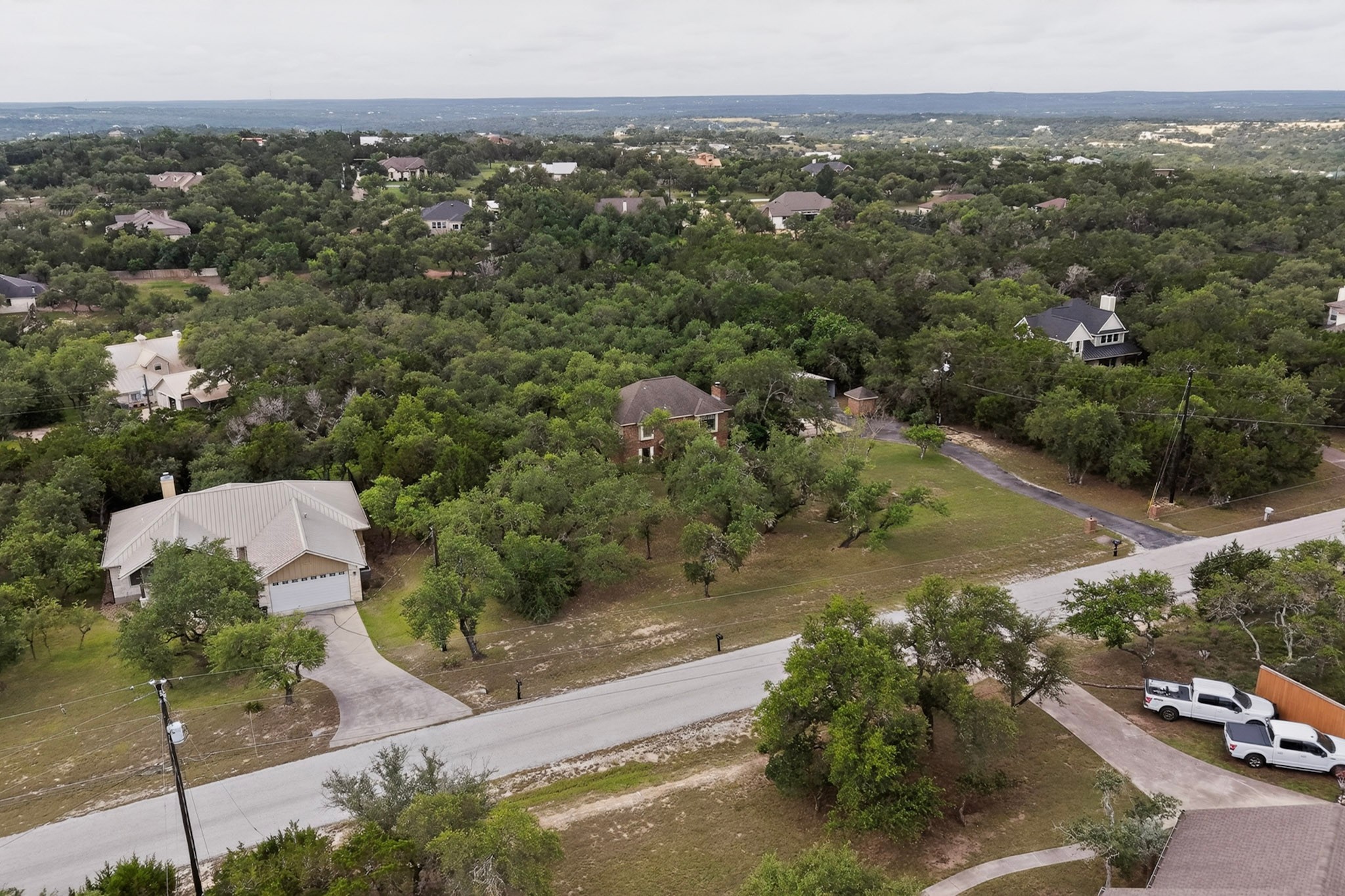 1003 Pier Branch Road Dripping Springs, TX 78620 - Photo 39 of 40 Perched on a verdant lot, this residence offers a scenic view of the surrounding treeline and neighborhood.