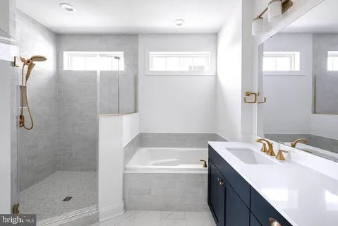 a bathroom with a tub sink and mirror