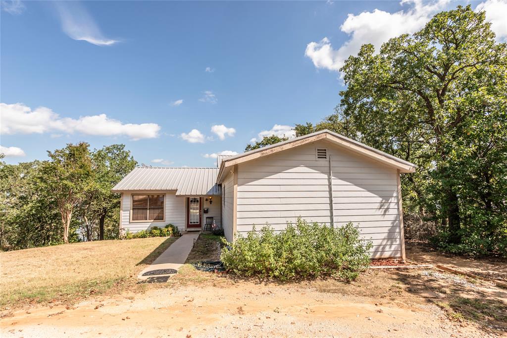 698 Storey Road Nocona, TX 76255 - Photo 8 of 34 View of front of property featuring a front yard and a metal roof
