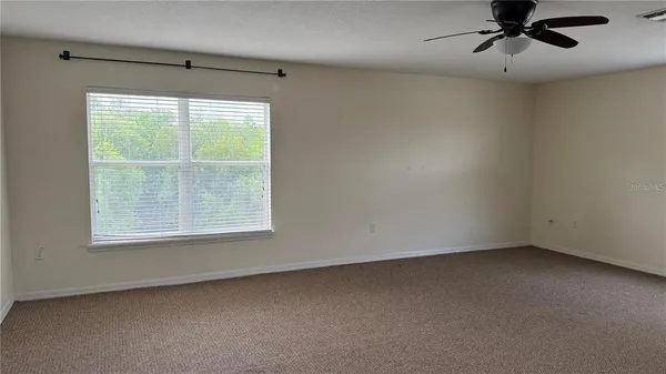 a view of a livingroom with a ceiling fan and window