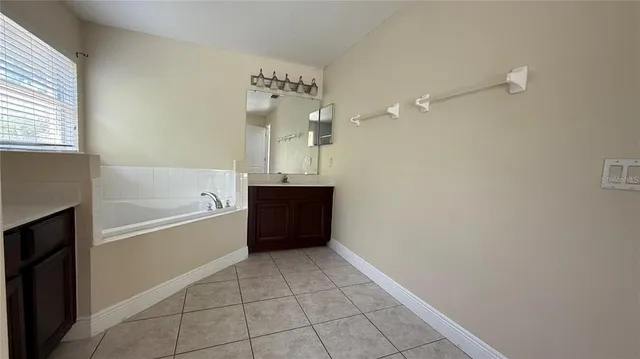 an empty room with wooden floor ceiling fan and windows