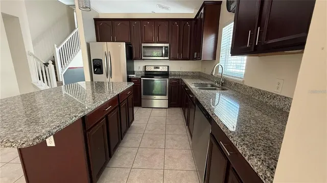 a kitchen with granite countertop cabinets sink and window