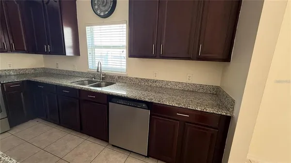 a kitchen with stainless steel appliances granite countertop a sink a refrigerator and a stove