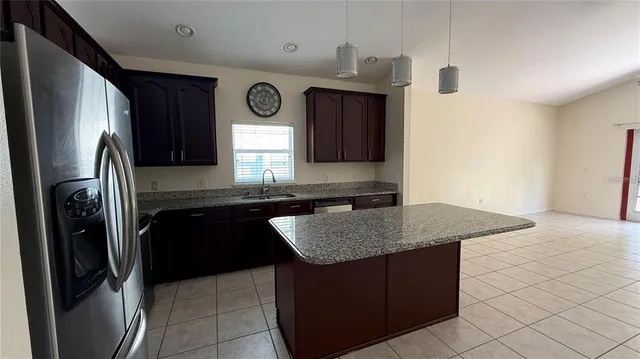 a view of a kitchen with a sink and a refrigerator