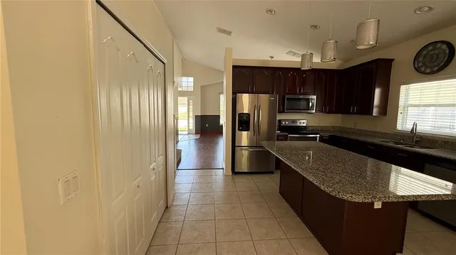 a kitchen with stainless steel appliances granite countertop a sink a stove a microwave and cabinets