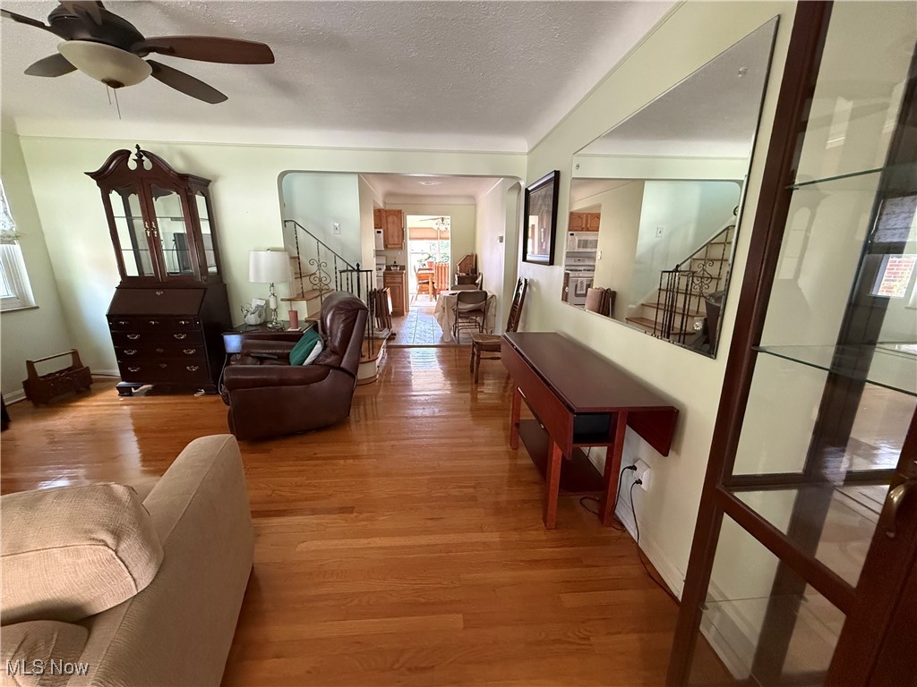 6289 Manchester Road Parma, OH 44129 - Photo 16 of 46 Living area with stairs, light wood-style floors, a textured ceiling, and ceiling fan