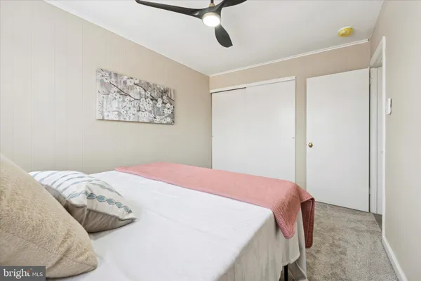 a bedroom with a bed and painting on the wall