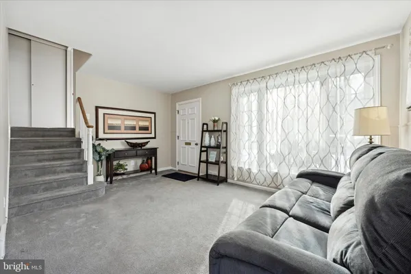 a living room with furniture a ceiling fan and a window