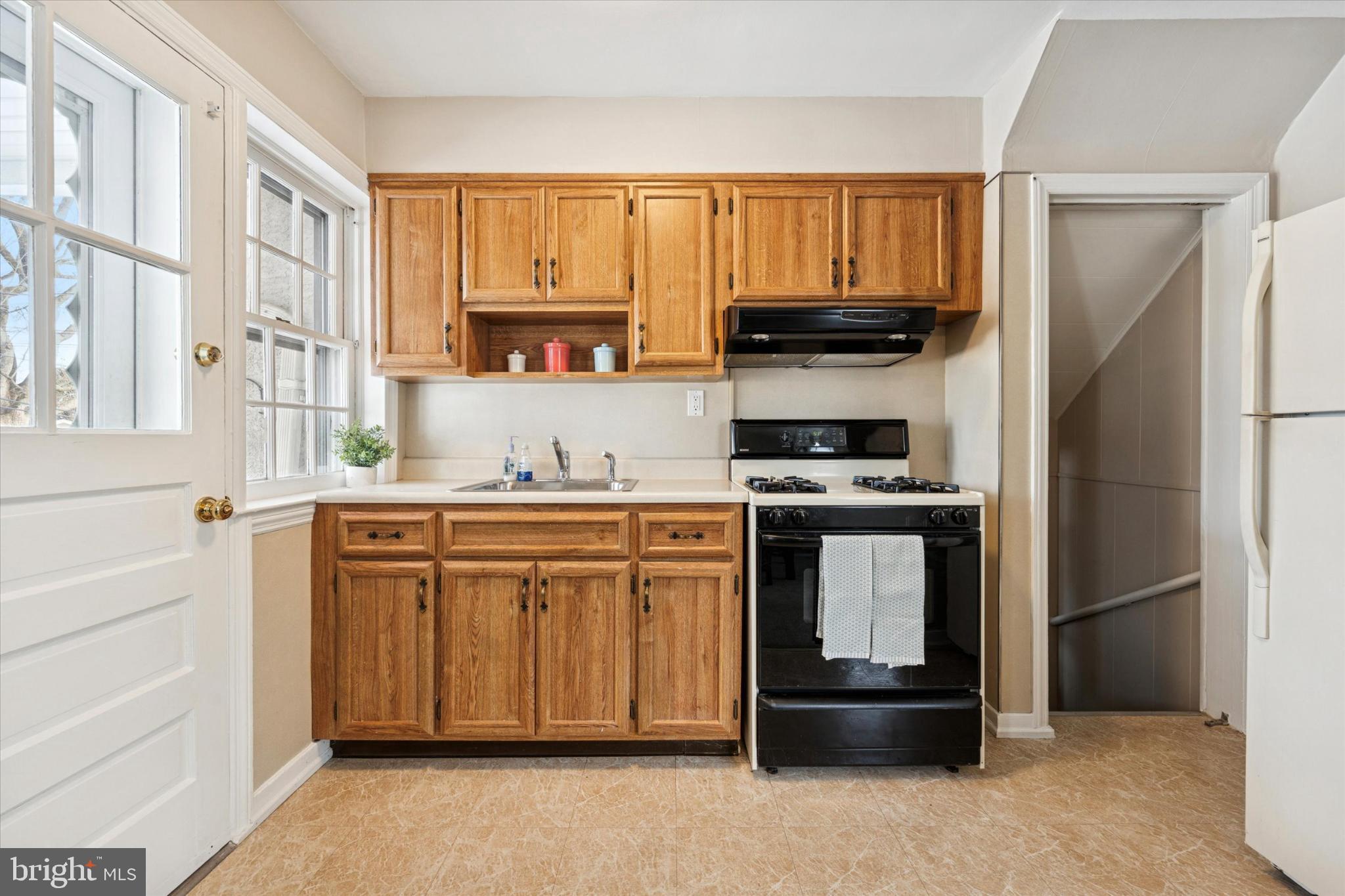 8711 Old Line Road Philadelphia, PA 19128 - Photo 7 of 21 a kitchen with granite countertop a refrigerator stove and microwave