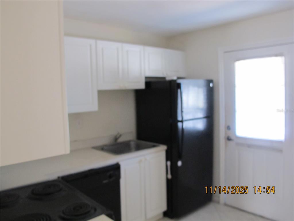 12405 Orange Blossom Oak Place, Unit 201 Tampa, FL 33612 - Photo 3 of 11 a kitchen with a refrigerator and cabinets