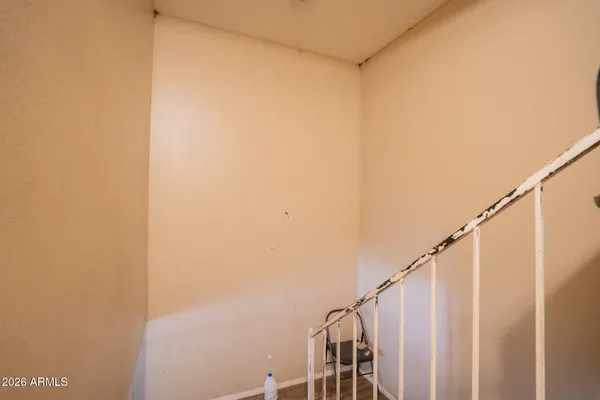 a view of staircase with railing and white walls