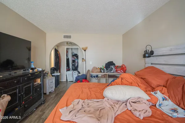 a bedroom with bed and a flat screen tv