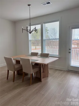 a dining room with furniture window entryway and wooden floor