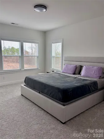 a large bed sitting in a bedroom next to a window