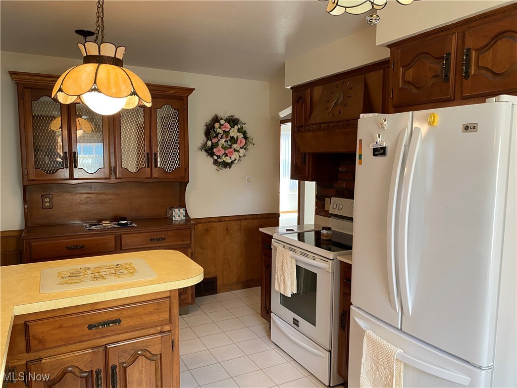 421 Omar Street Struthers, OH 44471 - Photo 7 of 31 Kitchen featuring a wealth of natural light, decorative light fixtures, white appliances, and light tile patterned floors