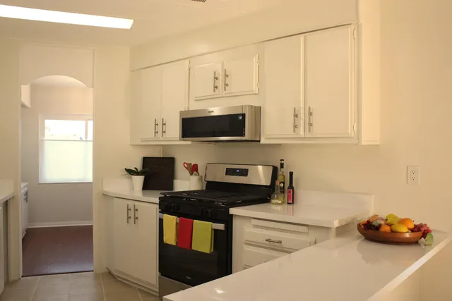 a kitchen with stainless steel appliances granite countertop a stove a sink and a microwave
