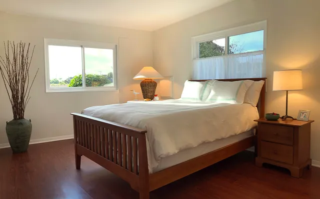 a bed sitting in a bedroom next to a window