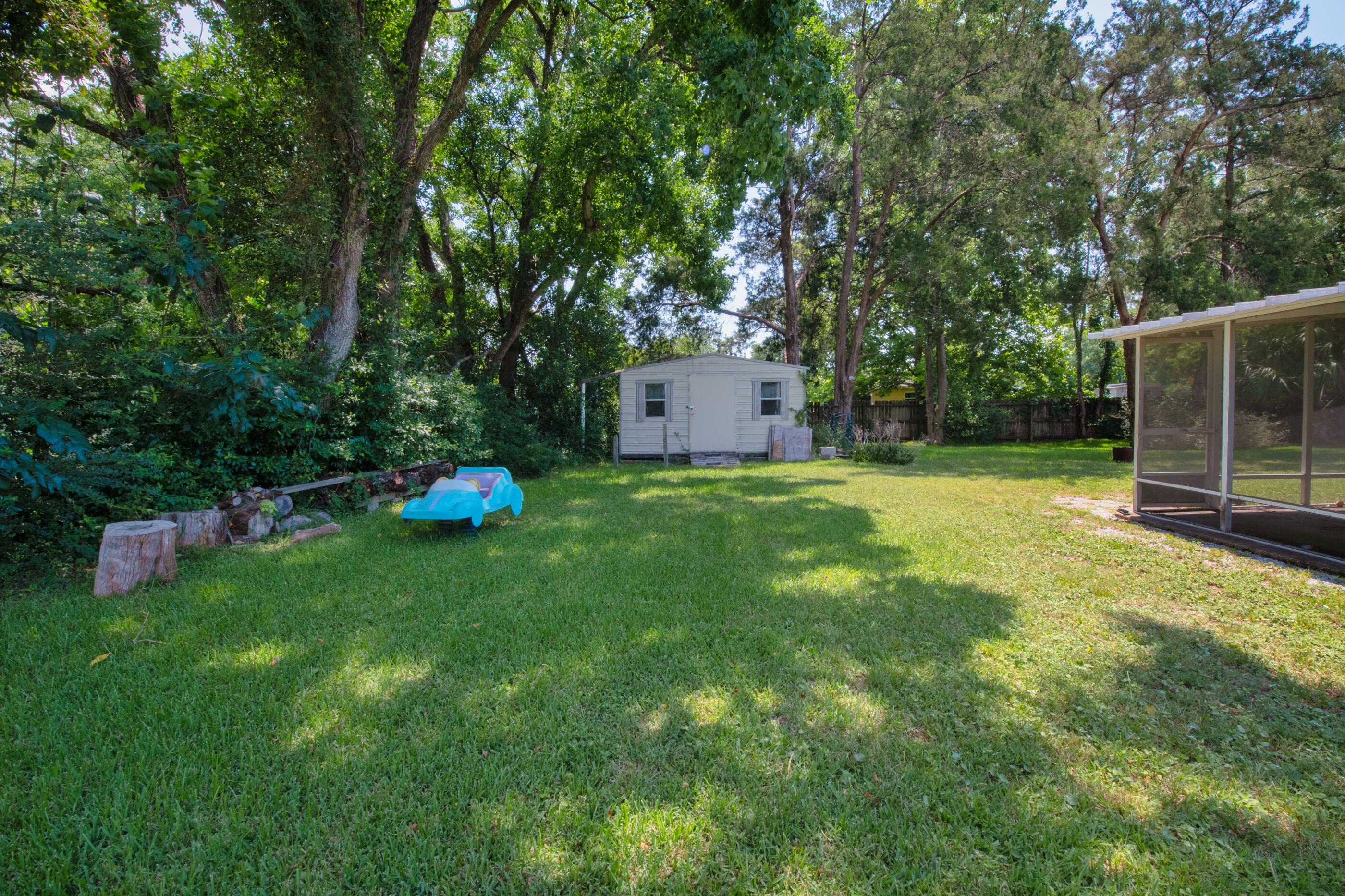 600 Shrewsbury Road Mary Esther, FL 32569 - Photo 21 of 25 a backyard of a house with plants and large trees