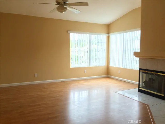 a view of an empty room with a window and a fireplace