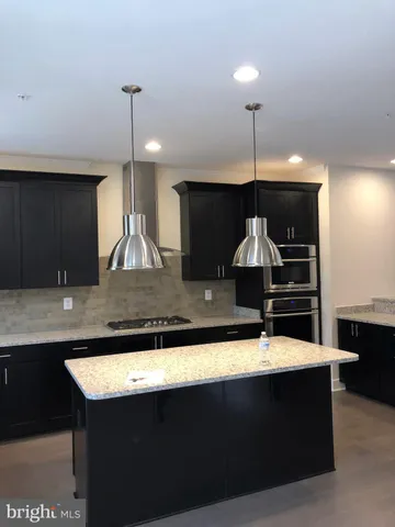 a kitchen with kitchen island a sink stainless steel appliances and cabinets