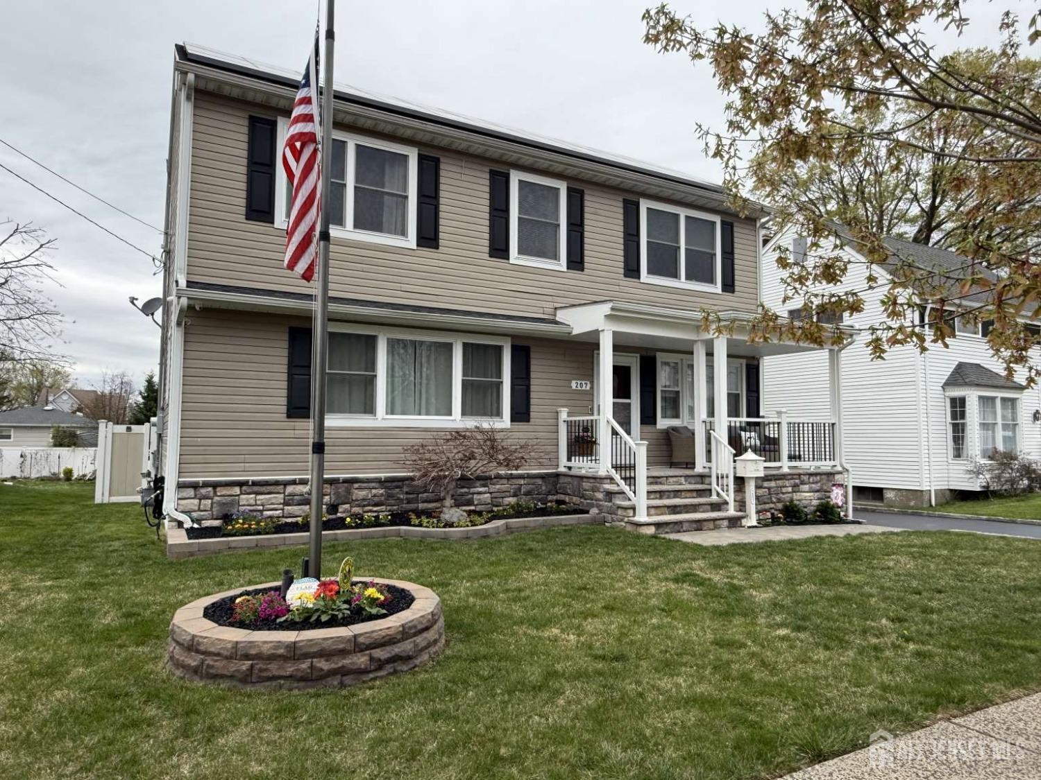 207 Remsen Avenue Avenel, NJ 07001 - Photo 1 of 24 a front view of a house with a yard fire pit and a fountain
