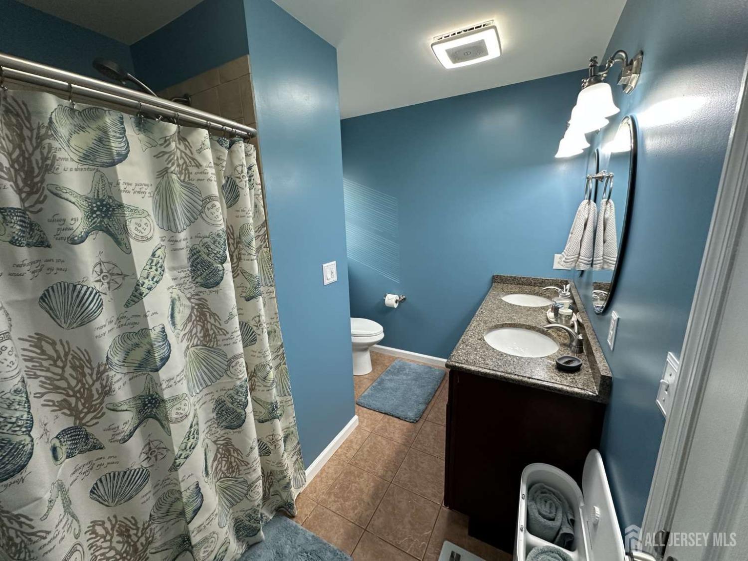 207 Remsen Avenue Avenel, NJ 07001 - Photo 13 of 24 a bathroom with a sink and mirror with toilet