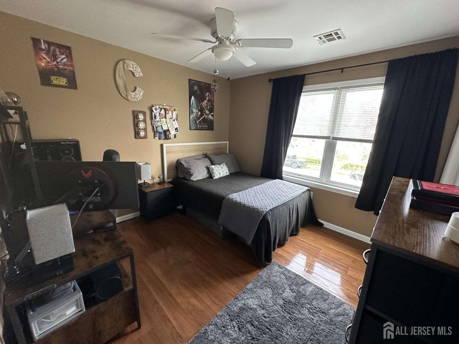 207 Remsen Avenue Avenel, NJ 07001 - Photo 15 of 24 a spacious bedroom with a bed a couch and a dresser next to a window