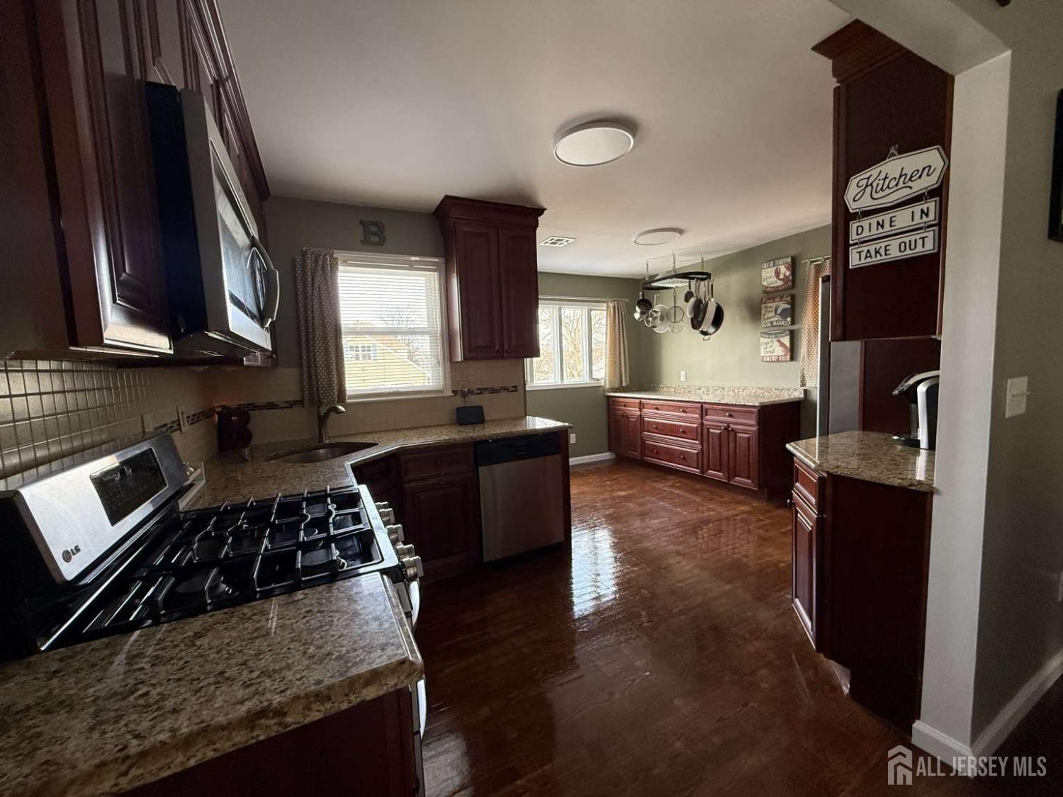 207 Remsen Avenue Avenel, NJ 07001 - Photo 5 of 24 a kitchen with granite countertop a stove and cabinets