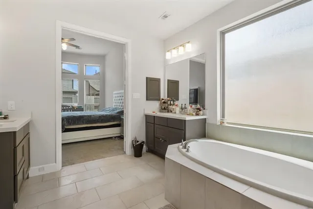 a bathroom with a tub sink and mirror